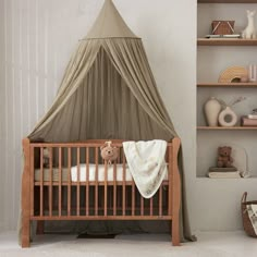 a baby crib with a canopy over it in a room filled with bookshelves