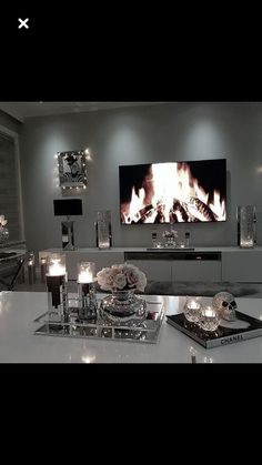 a living room filled with furniture and a fire place in the middle of it's wall