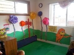 the children are playing in the playroom with paper flowers on the walls and floor