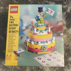 an advertisement for a lego birthday cake on the floor next to it's instructions