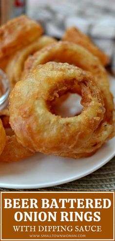 beer battered onion rings on a white plate with dipping sauce in the middle and text overlay that reads, beer battered onion rings