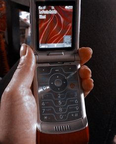 a person holding up a cell phone in their left hand and the screen is turned on