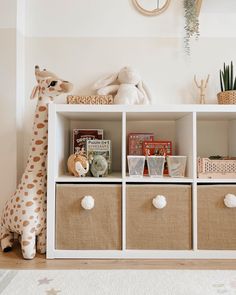 a white shelf with baskets and stuffed animals on it in a child's room