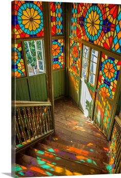 the sun is shining through stained glass windows in an old building with wooden floors and railings