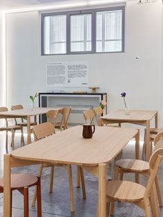 an empty room with wooden tables and chairs