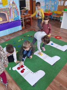 children playing with paper cutouts on the floor in a play room at school or preschool