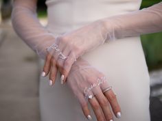 a woman wearing white gloves and holding her hands with the word love written on it