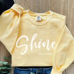 Wrap yourself in divine comfort and radiate your faith with our "Shine" Lightweight Crewneck Sweatshirt. Crafted from 100% cotton in a soothing butter hue, this cozy sweatshirt serves as a gentle reminder to let your inner light shine brightly, illuminating the world with love, grace, and unwavering faith. Embrace warmth, comfort, and spiritual inspiration with this uplifting wardrobe essential. This inspirational sweatshirt features a rolled forward shoulder and is printed with OEKO-TEX-certified low-impact dyes. Lastly, Comfort Colors is a proud member of the US Cotton Trust Protocol which means sustainable cotton sourcing that's good for the environment. Size Chart shown in images. .: 100% ring-spun cotton.: Light fabric (6.4 oz/yd² (217 g/m²)).: Relaxed fit.: Sewn-in twill label Unwavering Faith, A Gentle Reminder, Denim Hoodie, Christian Sweatshirt, College Gifts, Custom Bottles, Inner Light, Halloween School, Cute Sweatshirts