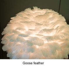 a large white feather lamp sitting on top of a table