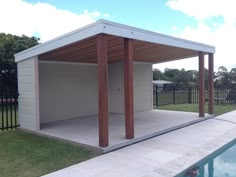 an outdoor pool with a covered pavilion next to the swimming pool and fenced in area