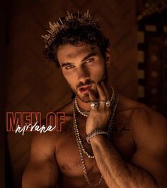 a shirtless man with his hand on his chin and necklaces around his neck