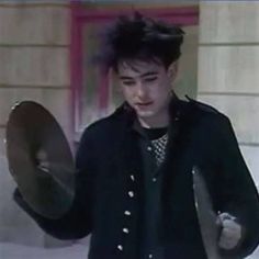 a young man holding a large metal object in his hand