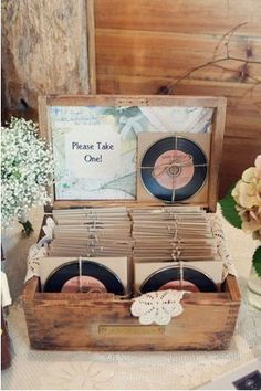 an old record box with two discs in it sitting on a table next to flowers