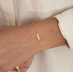 "A beautiful and elegant pearl bracelet featuring 3 dainty pearls. This bracelet is great for stacking or worn on its own for a delicate and minimalist look! Also makes a great gift for bridesmaids! - - - D E T A I L S - - -  * Made of 925 Sterling Silver * THICK plating of 14k Gold or Rhodium for a piece that is made to last! * Available in 6.25\" or 6.75\" + .5\" extension chain  * Made of the highest quality imitation pearls for an authentic look  * Nickel-free & Hypoallergenic  * Pearl Size: 3.5mm  * Lobster Clasp Closure  Made with 100% Pure Love! ♡ Comes in a gift-box, ready for gift-giving! 🎁 Ships same day! ✈️ For fast delivery! 🚀 Happy to answer any questions you may have! 🥰 Bracelets on Model: https://www.etsy.com/listing/1388390032/gold-bracelet-chain-bracelet-dainty?click_ke Dainty Pearl Bracelet, Gift For Bridesmaids, Pearl Bridal Jewelry, Bracelet Pearl, Bracelet Dainty, Jewelry Pearl, Dainty Bracelet, Pearl Bridal, Simple Bracelets