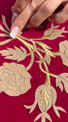 a woman is working on an embroidered fabric