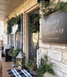 the front porch is decorated for christmas with evergreen wreaths and pine cones