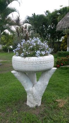 a planter made out of an old tire sits in the middle of a lawn