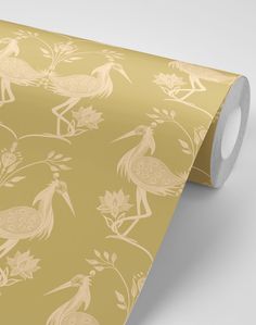 a gold wallpaper with birds and flowers on it's side, next to a roll of toilet paper