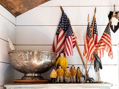 several american flags and figurines on a mantle