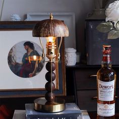 a bottle of dewworth's whisky sitting on top of a table next to a lamp