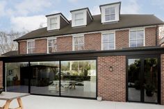 a large brick building with glass doors on the front and side windows that open up to an outside patio area