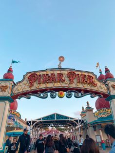 people are walking through the entrance to an amusement park with a sign that says party pier