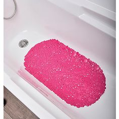 a pink bath mat sitting on top of a white bath tub