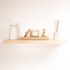 a shelf with candles, vases and other items on it