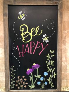 a chalkboard with the words bee happy written on it and flowers painted on it