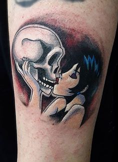 a person with a skull tattoo on their arm