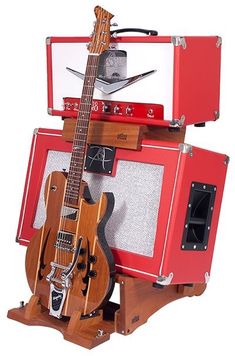 an electric guitar and amp are stacked on top of each other in front of a red case