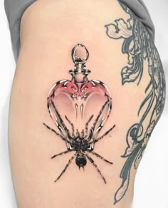 a woman's thigh with a spider on it and a perfume bottle in the shape of a heart