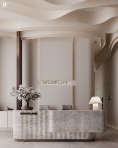 an elegant reception area with white walls and flooring is featured in this image, the front desk has a vase full of flowers on it