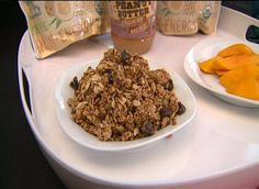 there is granola and orange slices on the plate next to each other in this tray