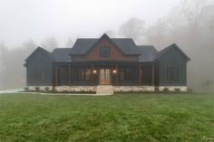 a house in the fog with its front porch lit up and windows on each side