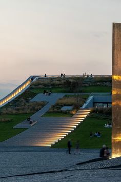 people are walking up and down the stairs at dusk, with lights shining on them