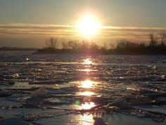 the sun is setting over some ice floes