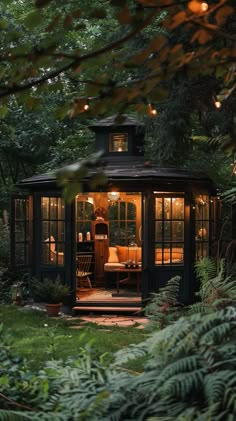 a gazebo in the middle of some trees with lights hanging from it's roof