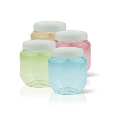 four different colored jars with lids on each one and the other half empty, all lined up