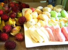 there are many different types of fruits on the table together, including rambutans and macaroni