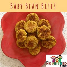 a red plate topped with food on top of a white countertop next to a sign that says baby bean bites