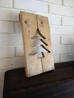 a wooden christmas tree cut out on top of a table