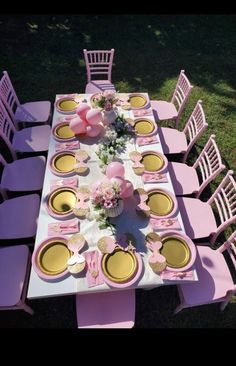 the table is set with pink and yellow plates