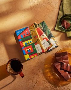 a table topped with a plate of food next to a cup of coffee and a book