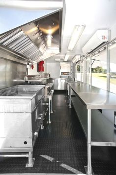 the inside of a commercial kitchen with stainless steel counter tops and appliances on each side