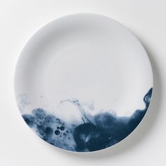 a white plate with blue and black designs on the rim, against a white background