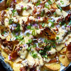 a pizza covered in cheese and toppings sitting on top of a pan filled with foil