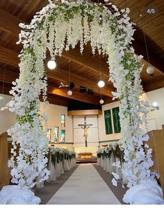 an aisle decorated with white flowers and greenery for a church wedding or special event