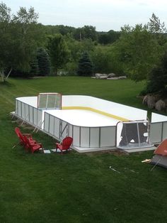 an outdoor ice rink in the middle of a grassy area with chairs and tables around it