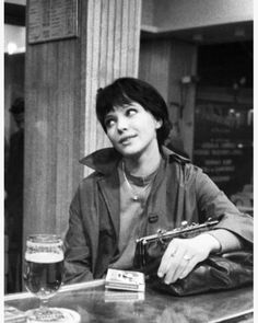 a man sitting at a table with a beer in front of him and looking up